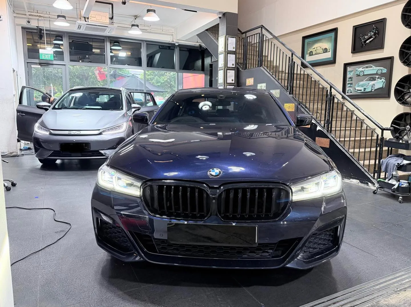 Dark blue metallic BMW sedan with LED headlights on front.