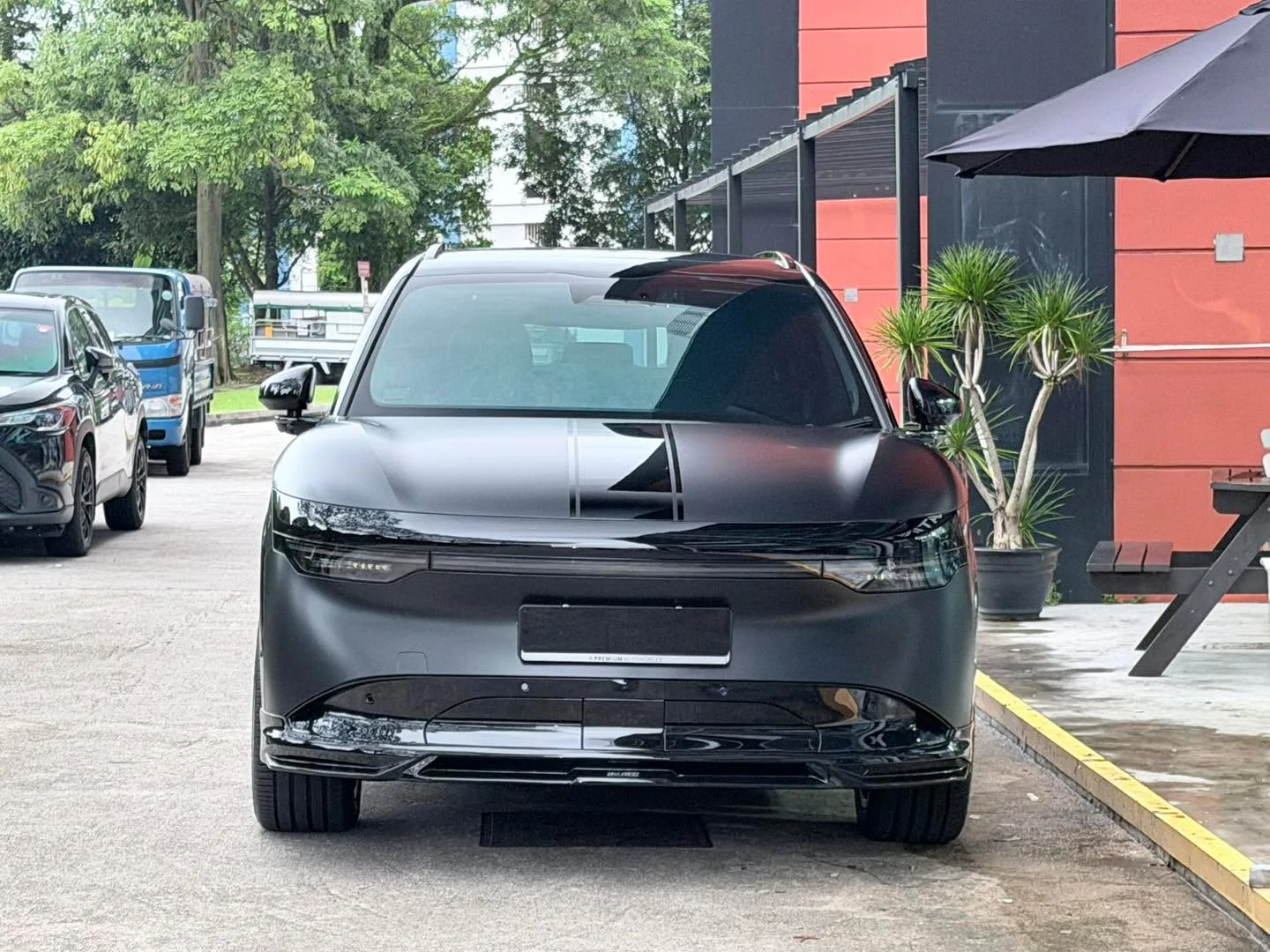 A gunmetal grey SUV parked at the workshop forecourt, viewed from the front.