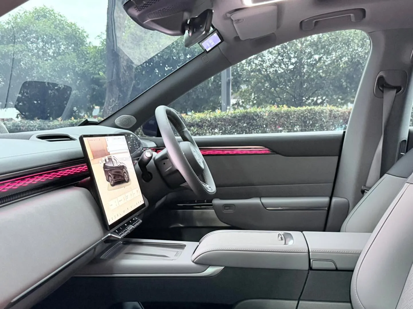 Interior cabin view showing white leather seats, white and grey dashboard, and a tinted windscreen, viewed from the driver's position.