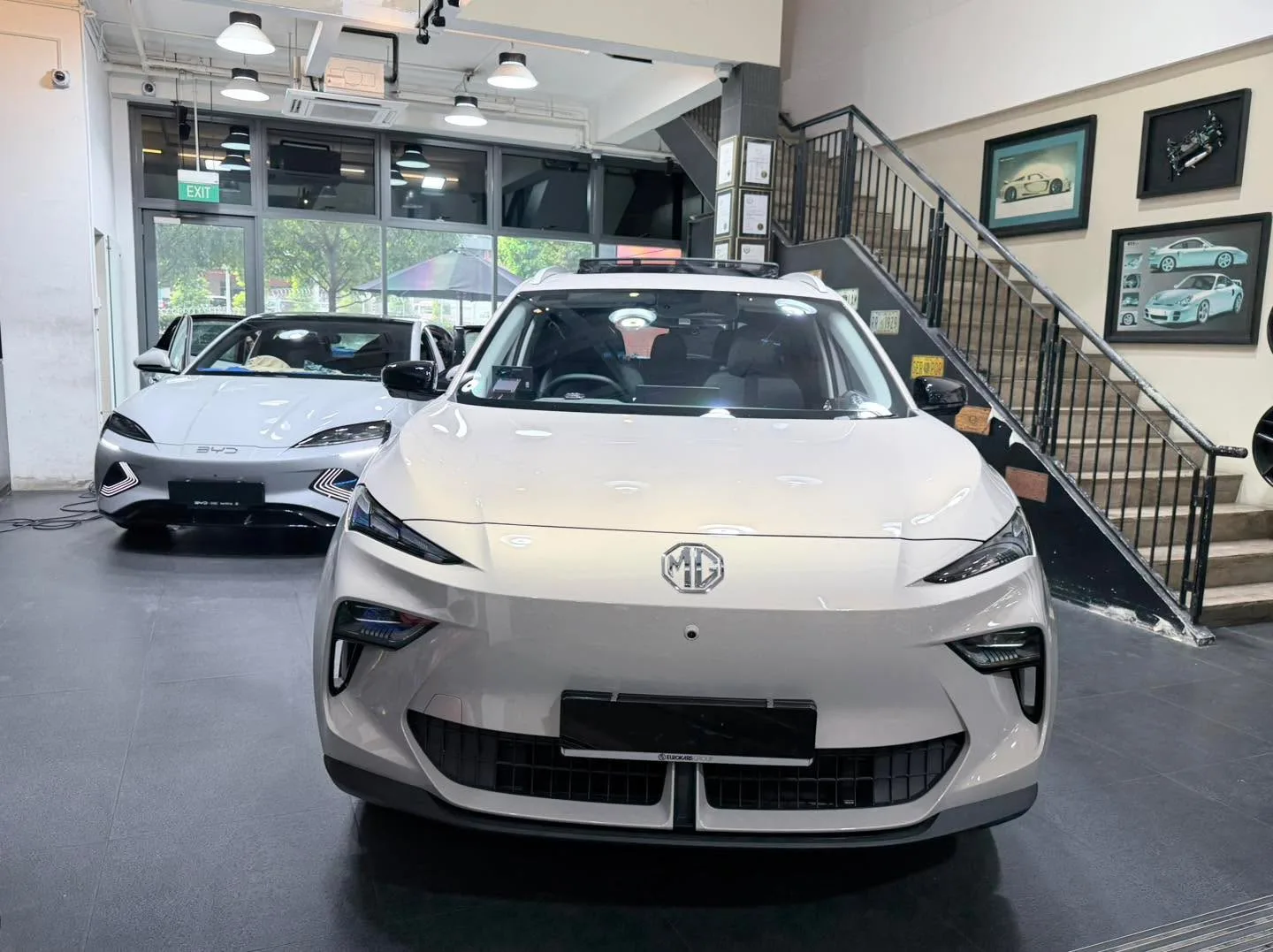 A white saloon with prominent kidney grille and MG badge, parked indoors.