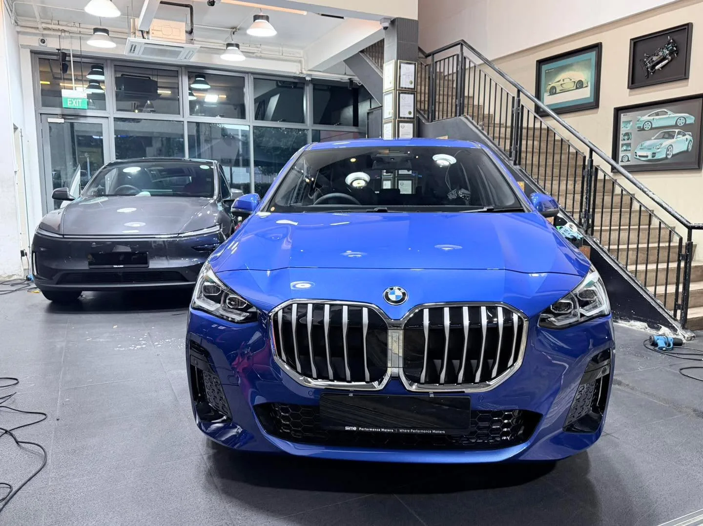 A blue BMW SUV with distinctive kidney grille, front view.