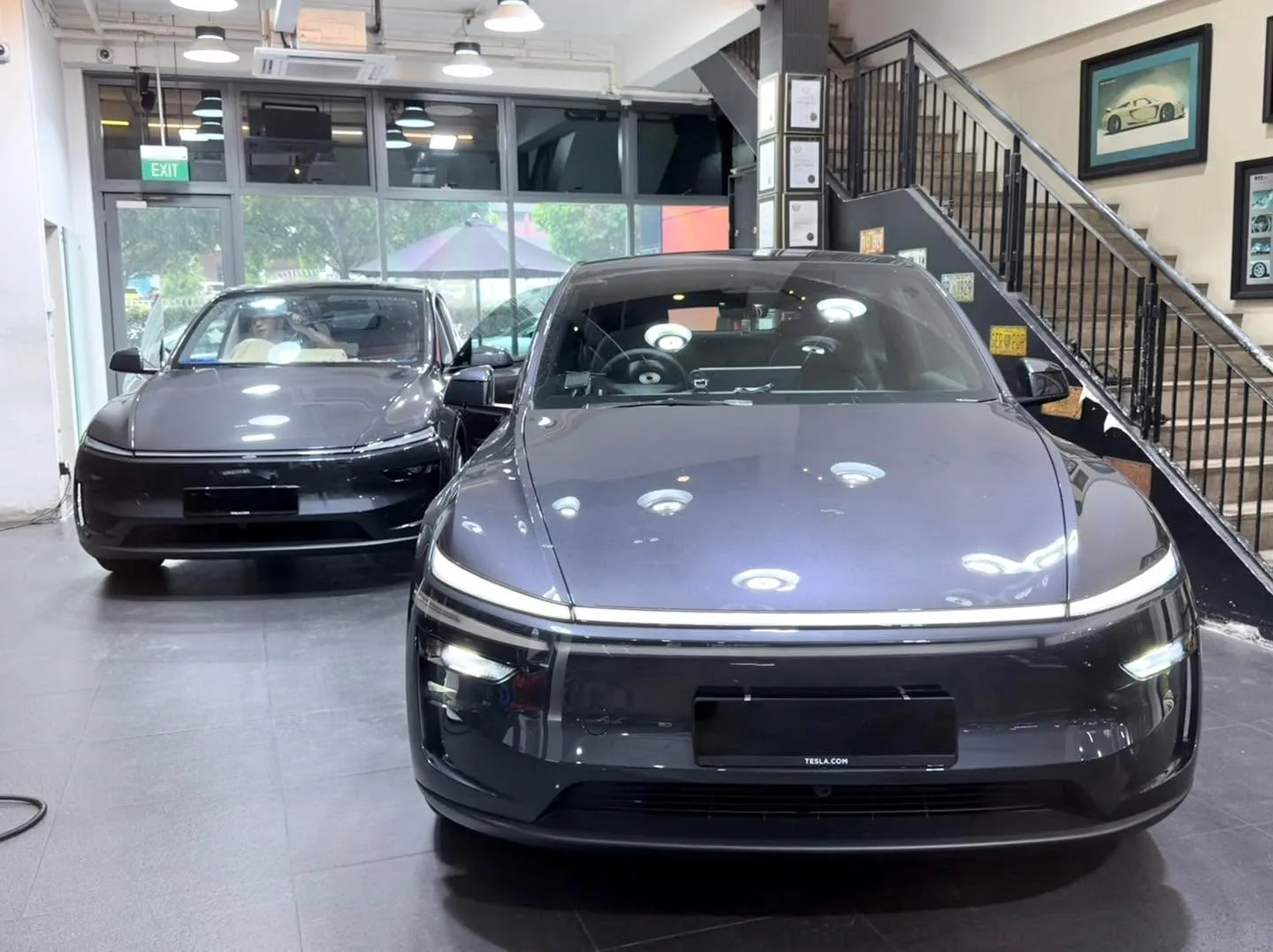 A dark-coloured Deepal S07 electric saloon and another vehicle inside the workshop.