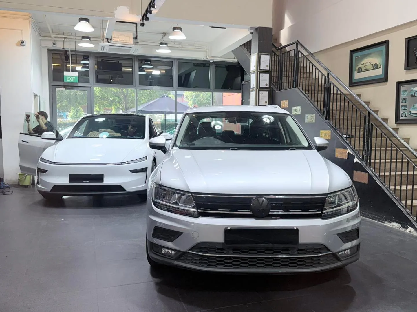 White Lexus ES and white Volkswagen Tiguan parked indoors.
