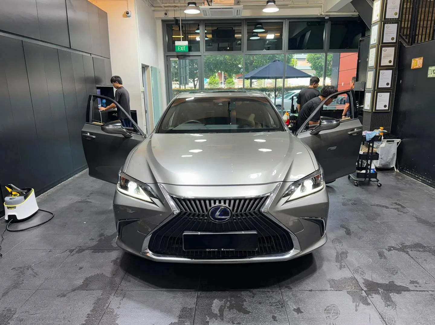Grey saloon being tinted with technician working on the door window.