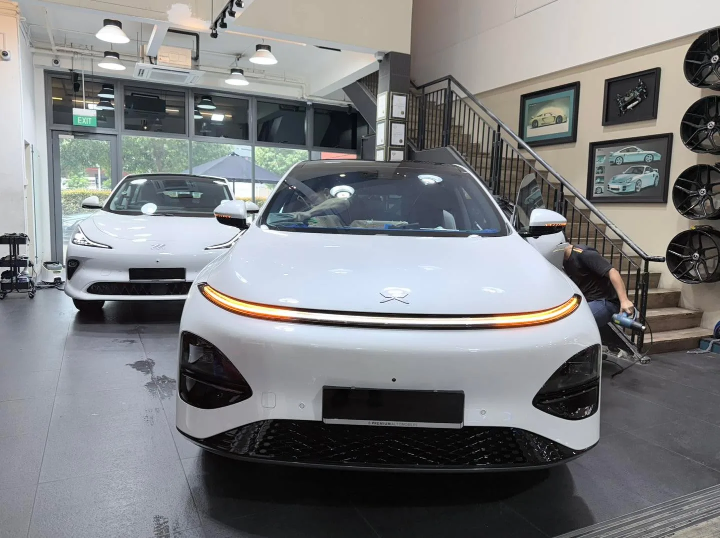 A white XPENG G6 SUV viewed from the front in the workshop interior.