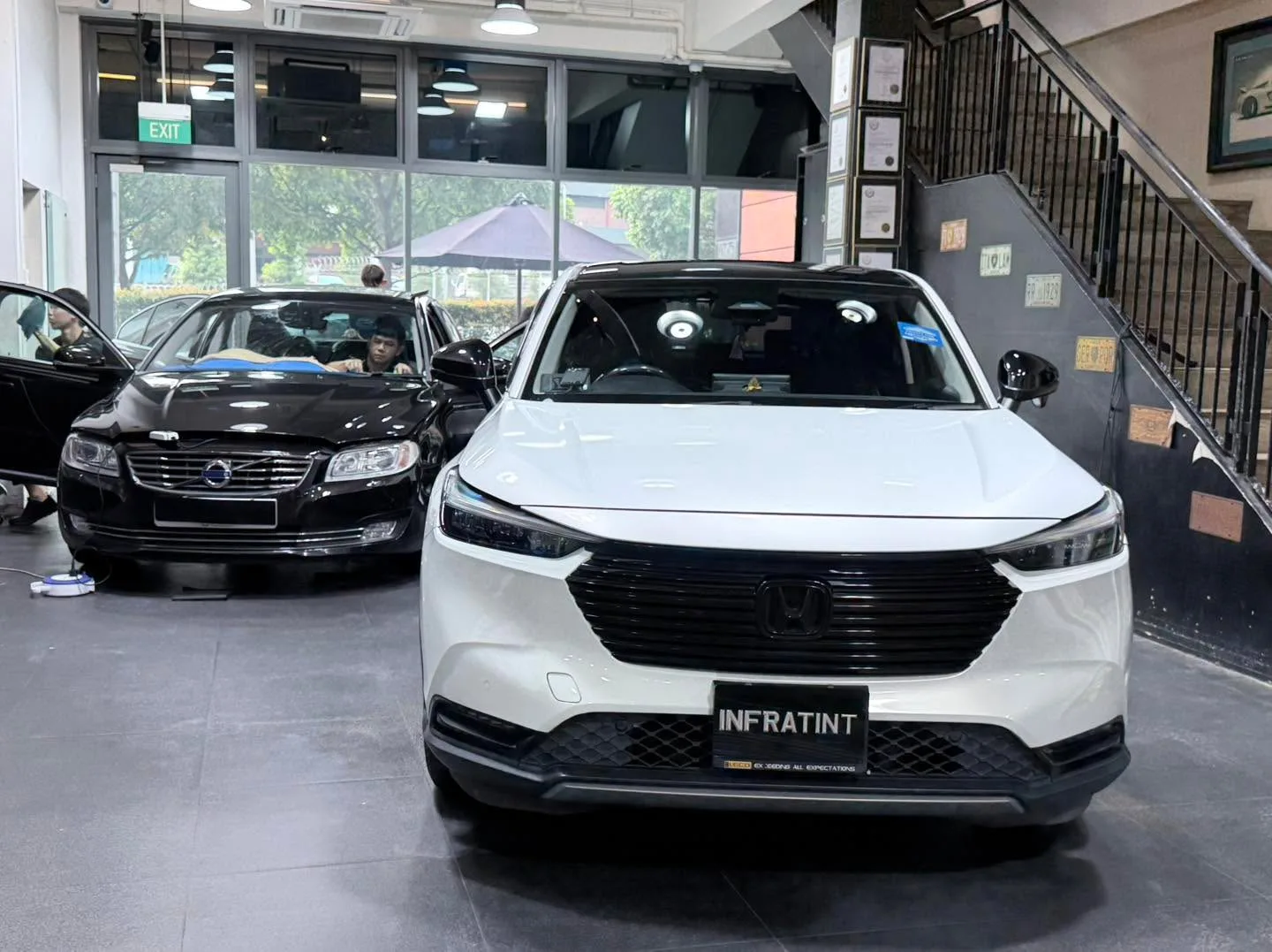 A white BYD Atto 3 compact SUV parked indoors with other vehicles.