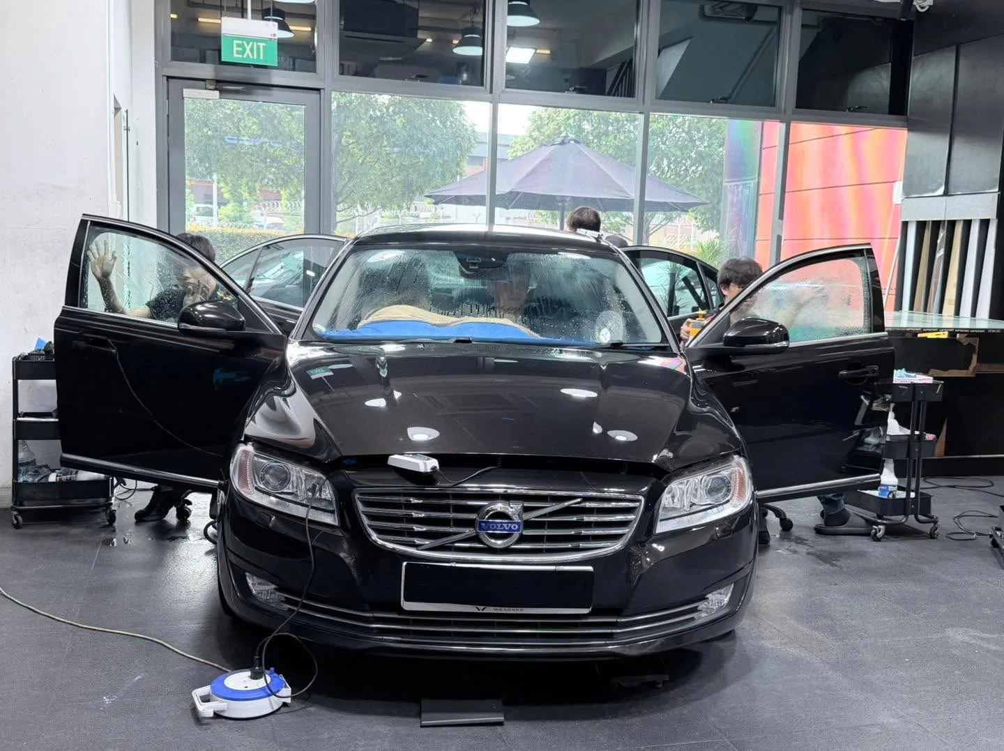 A black Honda Accord with doors open displayed indoors.