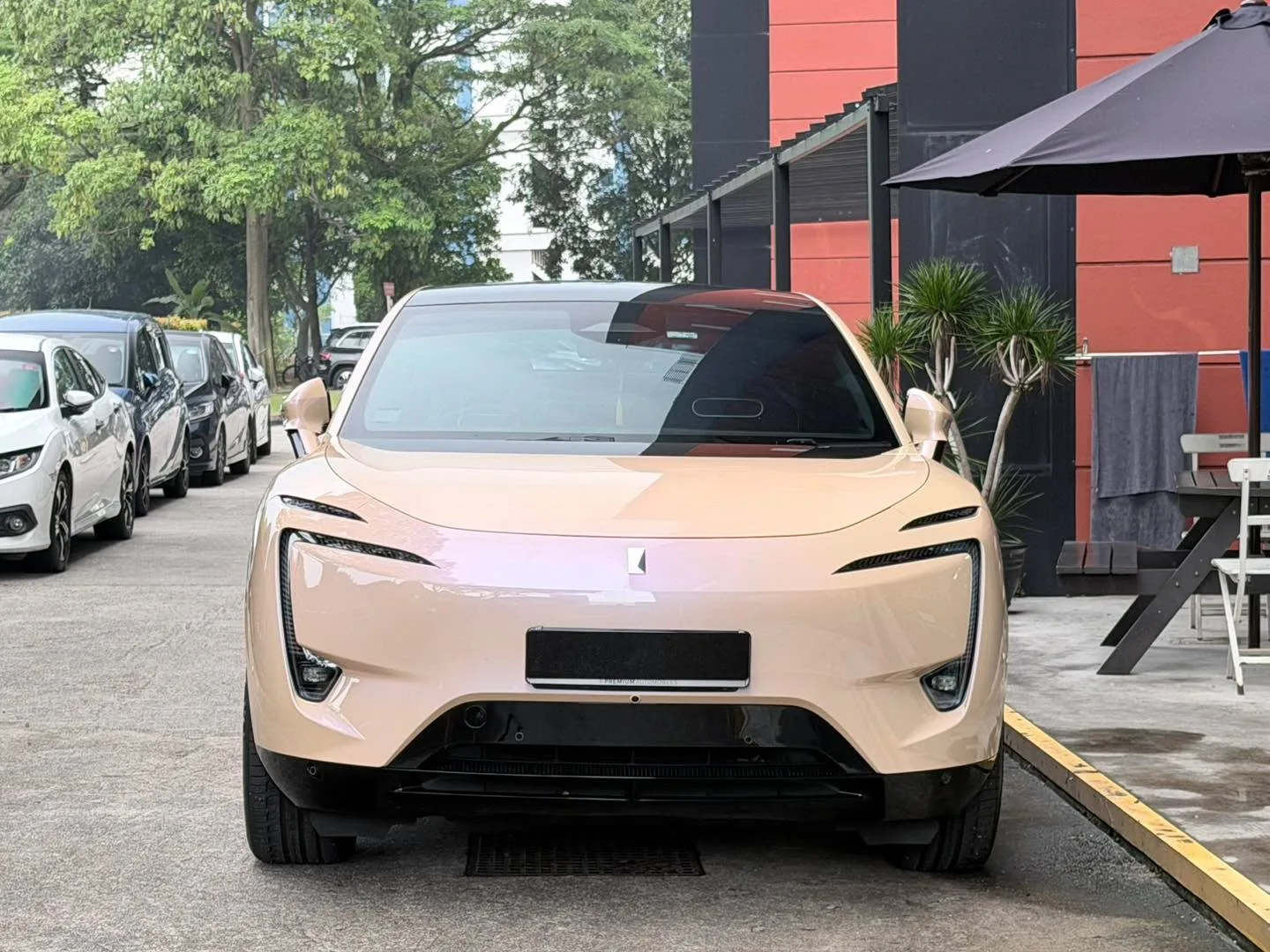 A cream-coloured Avatr 11 SUV parked in the workshop forecourt with black-tinted rear windows, viewed from the front.