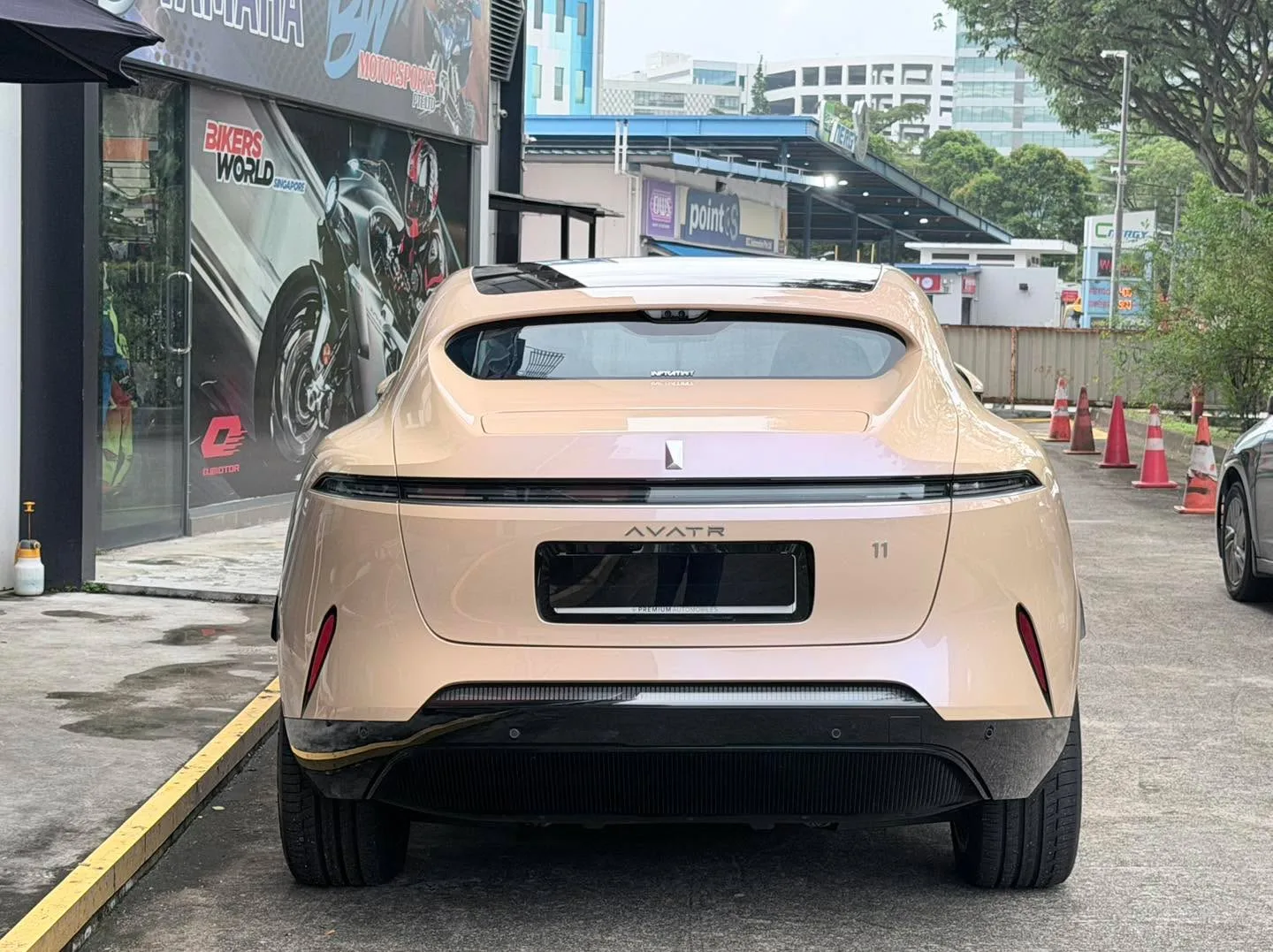 Rear view of the cream Avatr 11 with black-tinted rear windows and side glass, parked on a street.