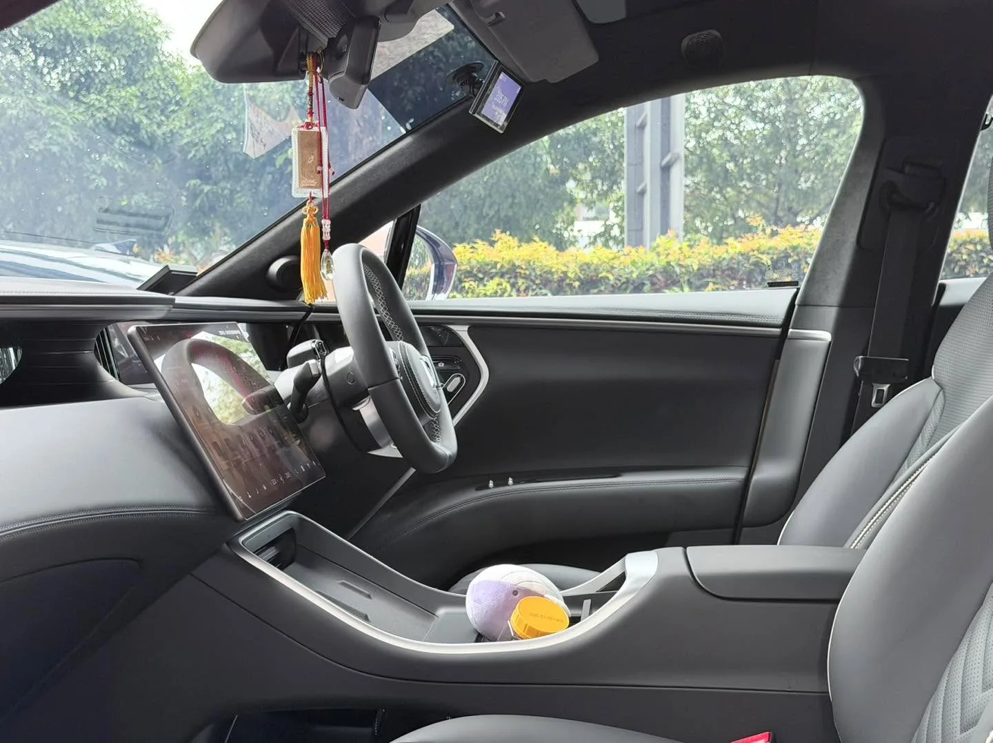 Interior view of the Avatr 11 showing the steering wheel and dashboard framed by side windows with dark tint applied.
