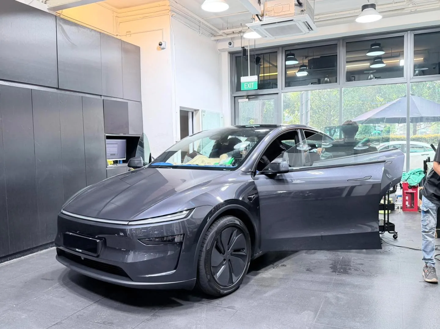 A grey electric hatchback with modern design in an indoor workshop space.