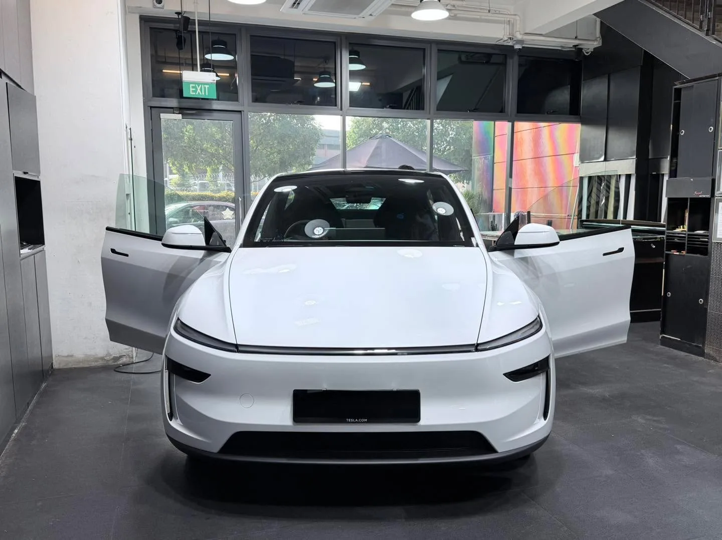 White Tesla Model Y Juniper, front view, doors open.