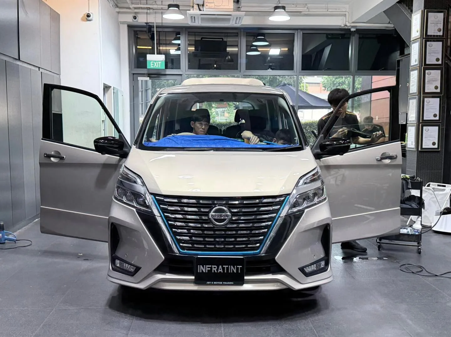 White Nissan Serena MPV with doors open, doors being worked on.