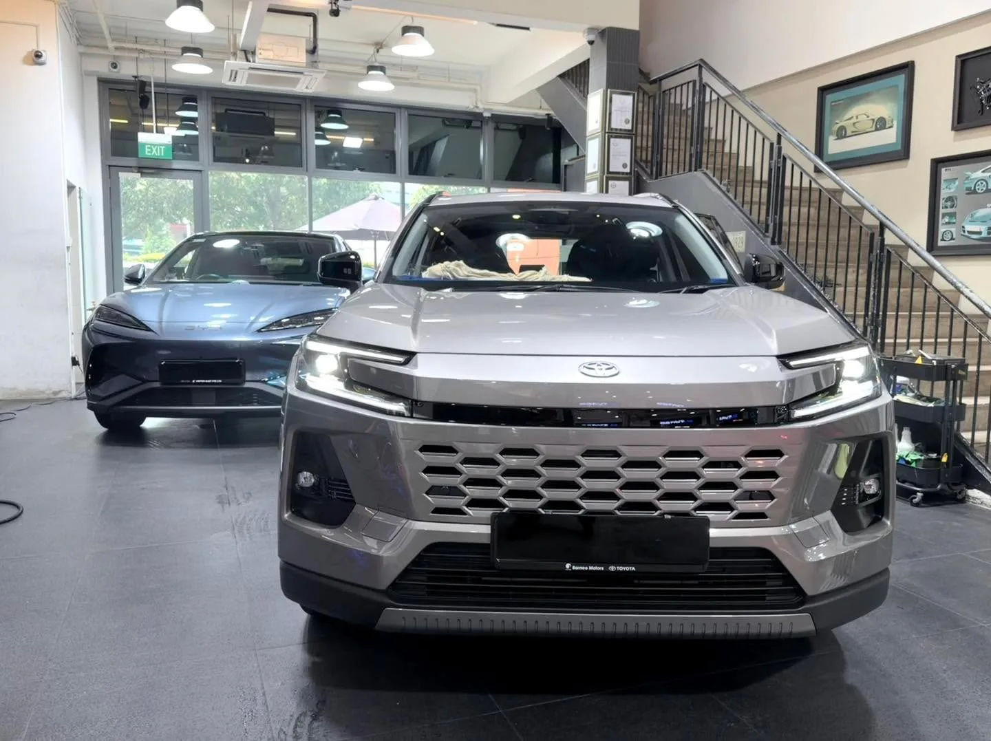 A grey SUV and a black sedan parked in the workshop interior.