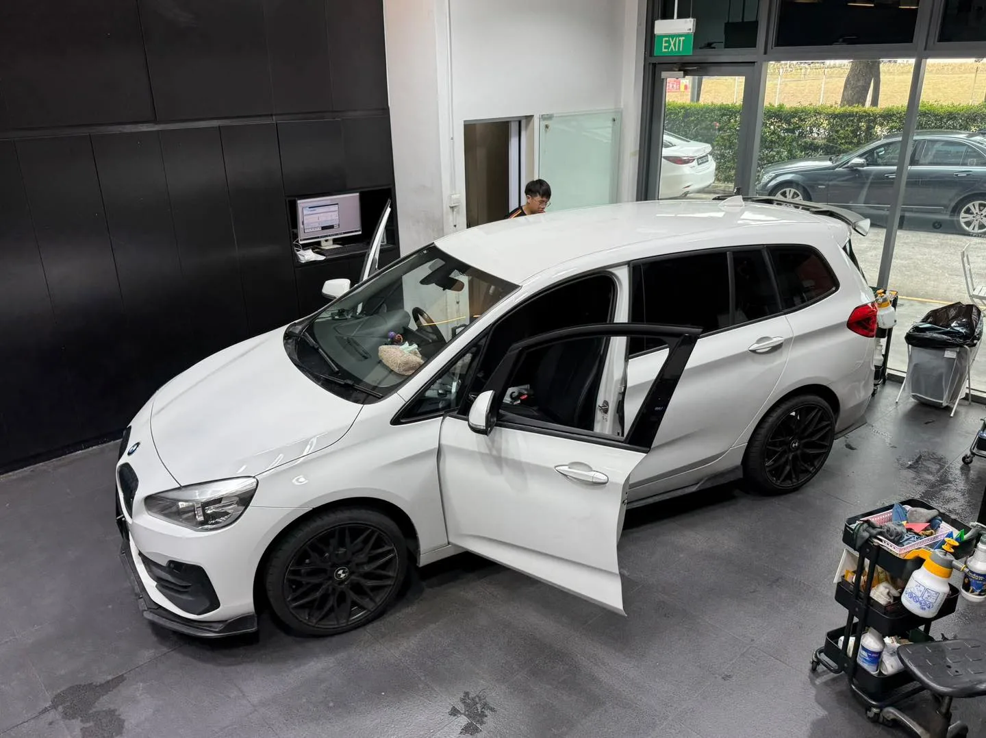 A white Mini hatchback with doors open for tinting work.
