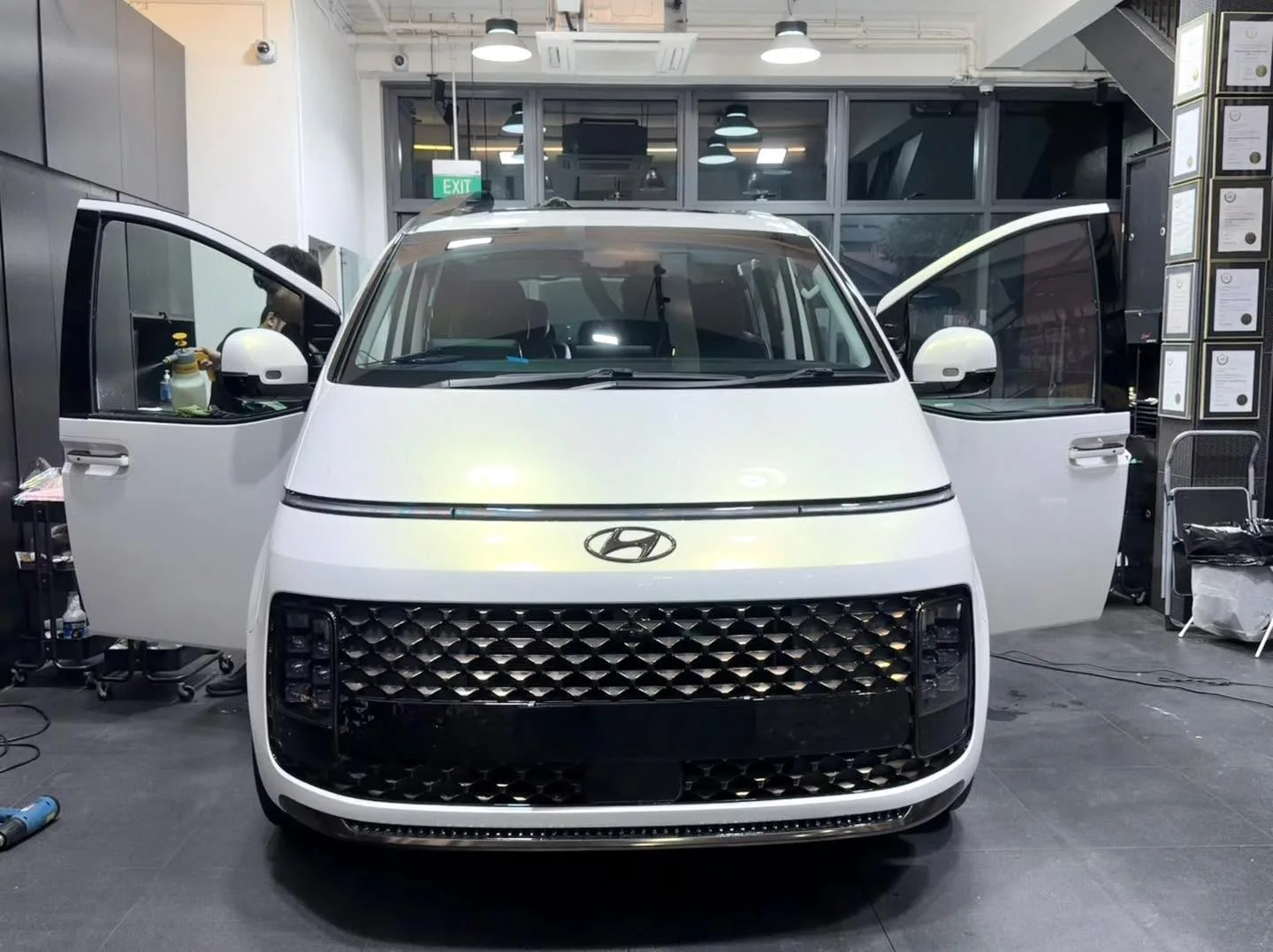 A white compact SUV with doors open, viewed from the front, parked indoors.