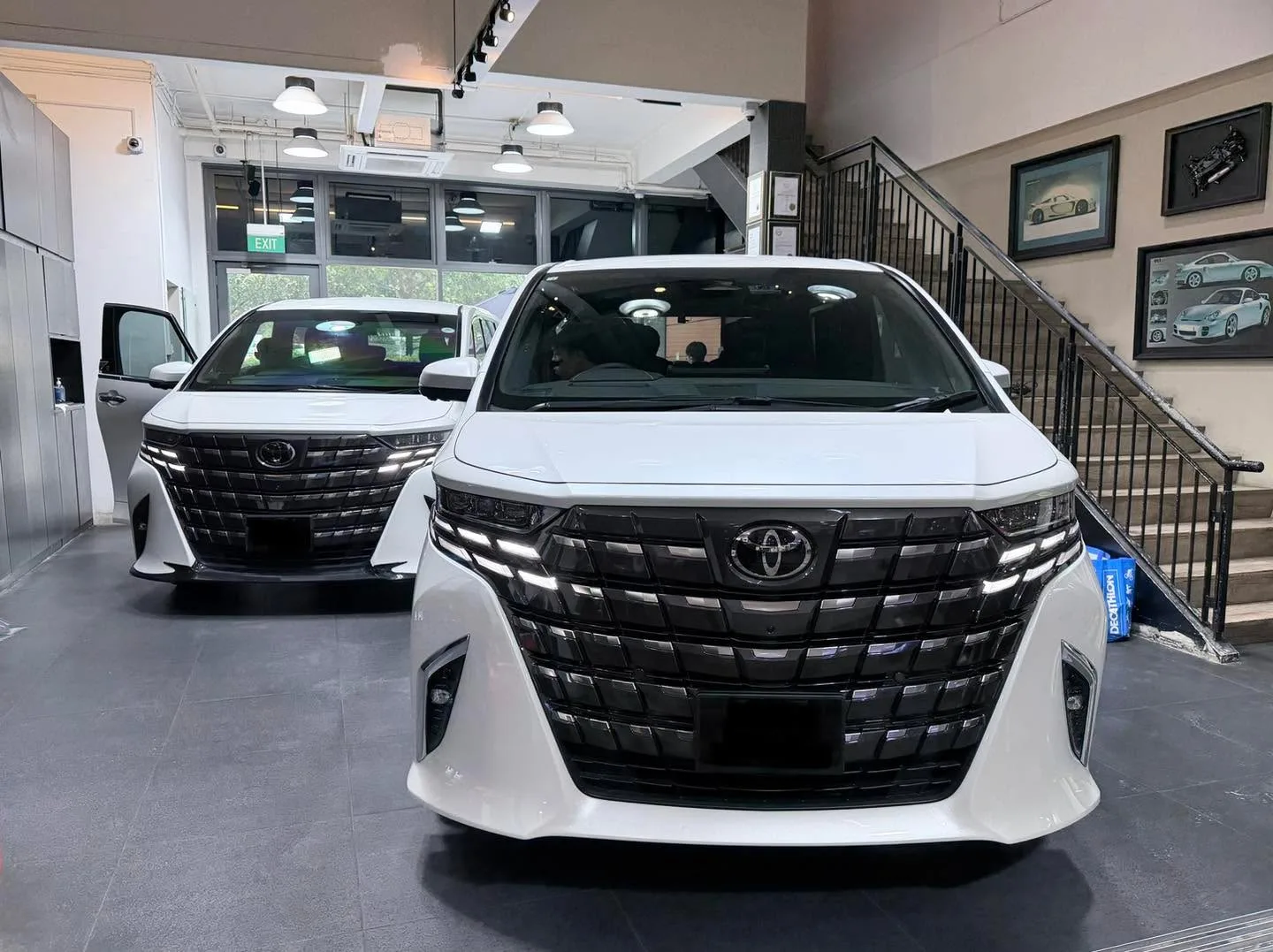 A white Toyota Alphard and a white Toyota Alphard parked indoors.