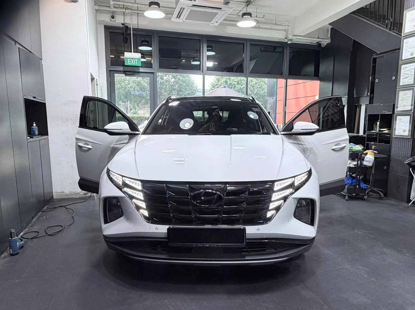 A white Hyundai SUV with driver and passenger doors open.