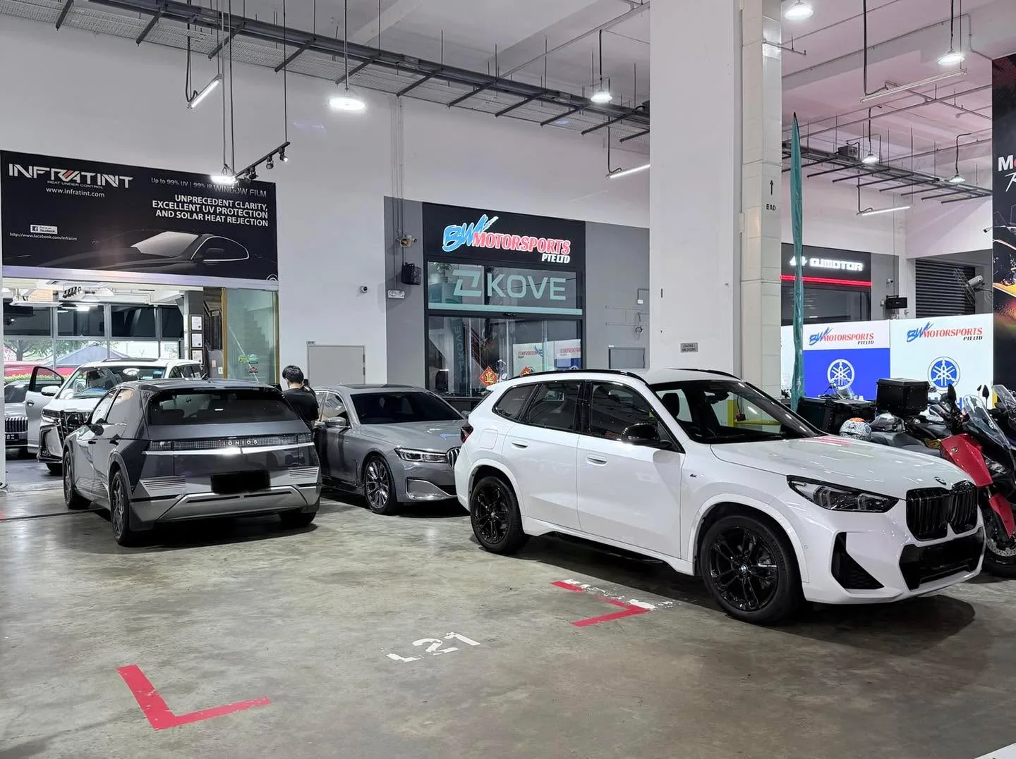 A dark grey BYD Atto 3 SUV and other vehicles in a multi-level carpark area.