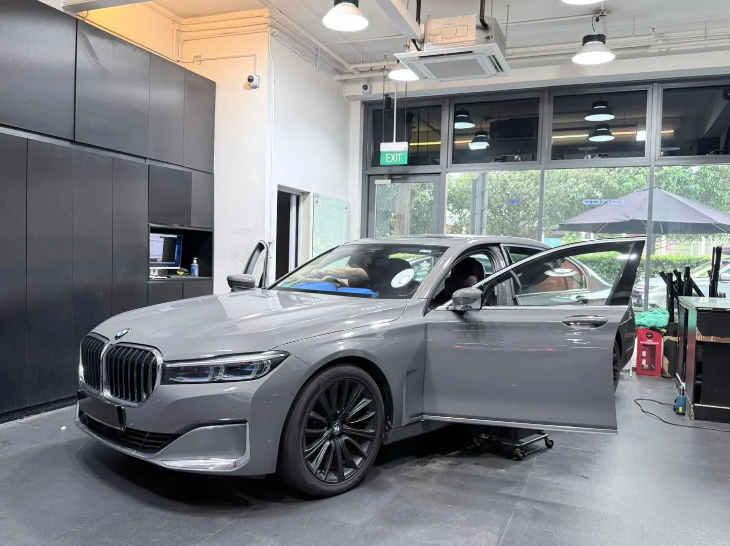A grey BMW 740 sedan head-on positioned indoors with doors closed.
