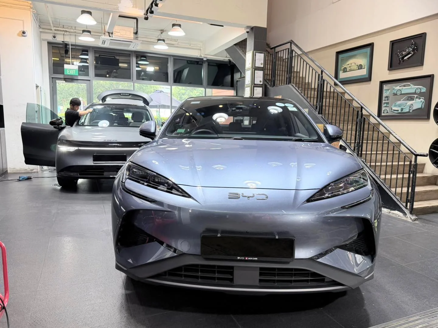 A silver sedan with distinctive headlights positioned in the workshop interior.