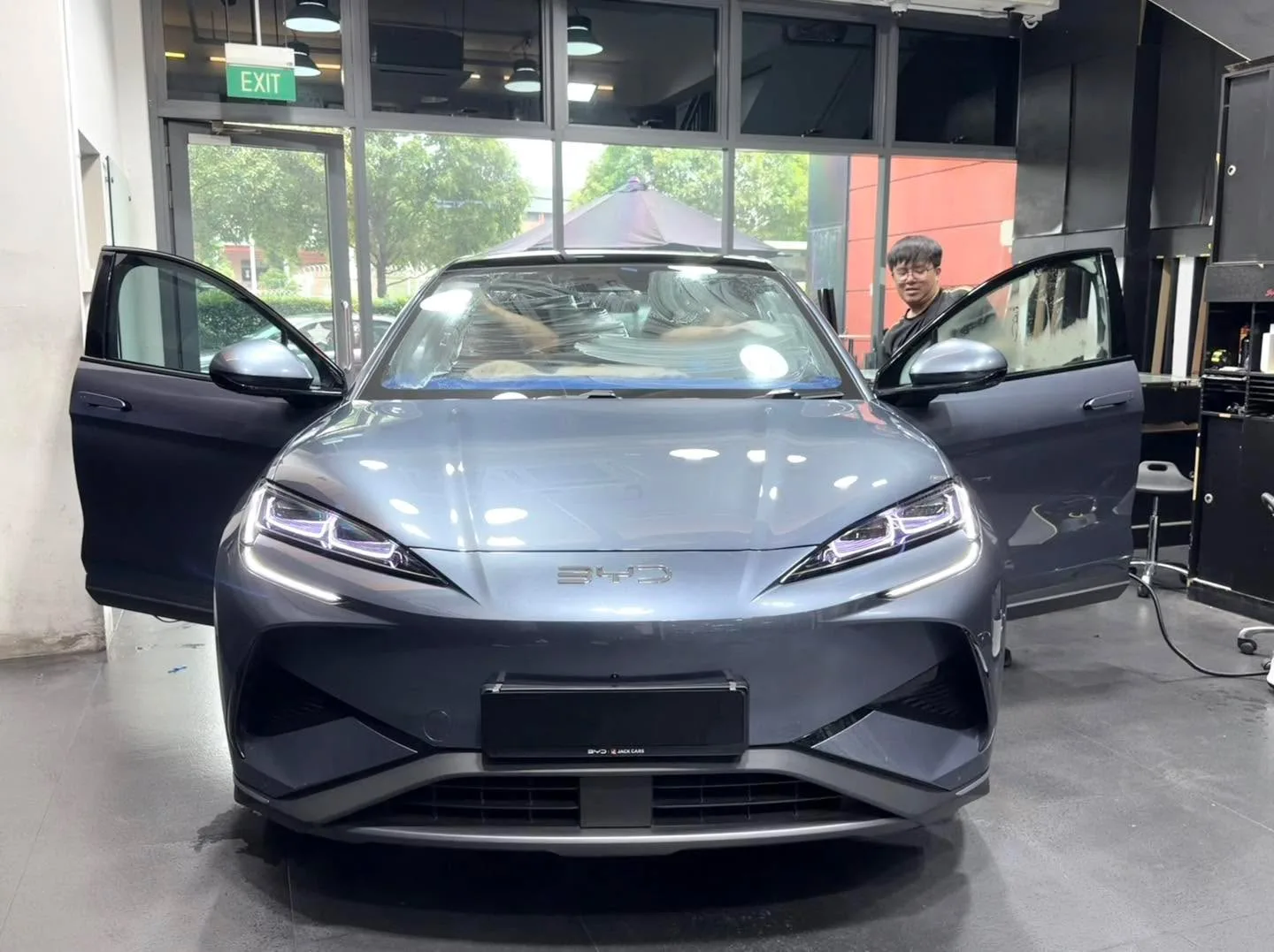 A silver compact SUV with one door open in the workshop.