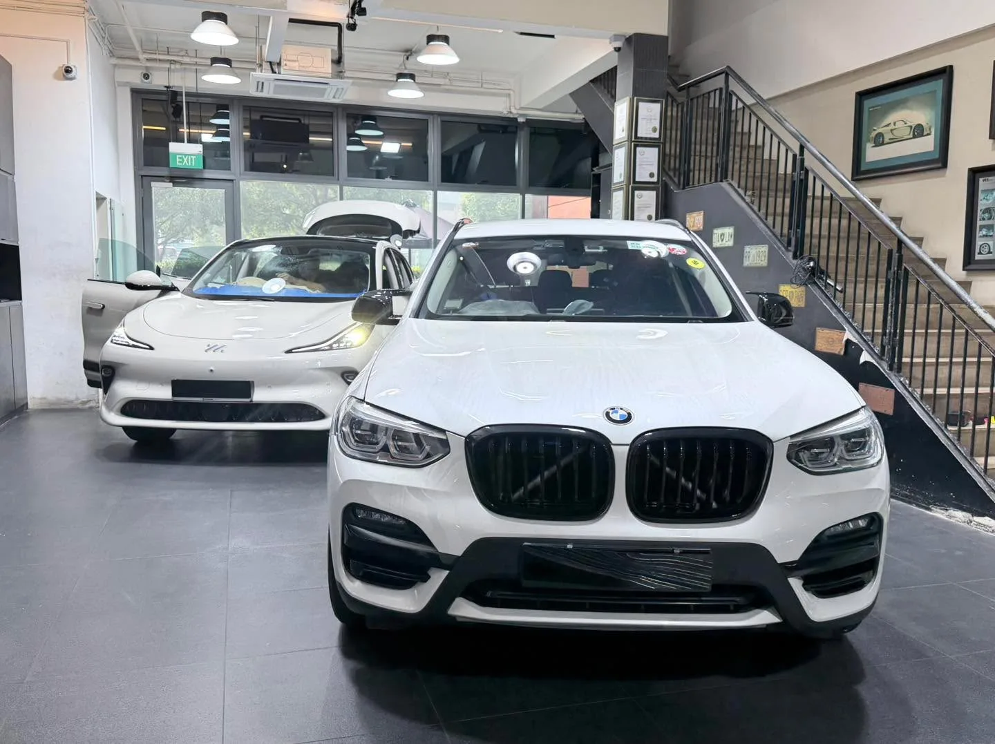 A silver Mercedes-Benz GLC SUV and a white Hyundai sedan parked inside the workshop.