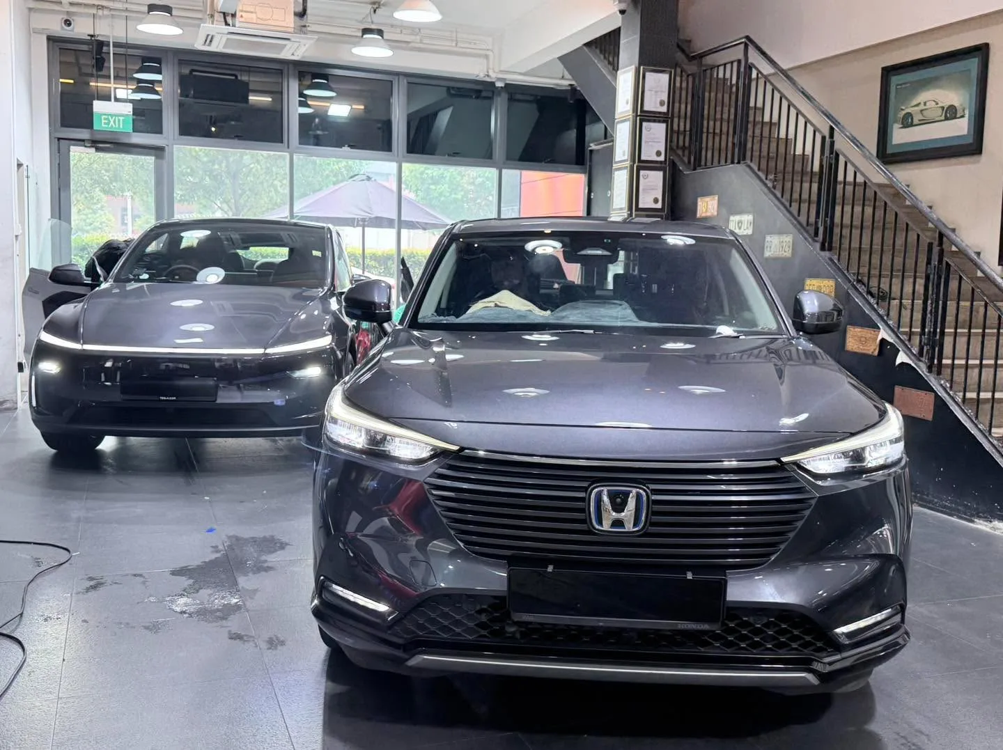 Black and grey sedans, red Nissan visible on right.