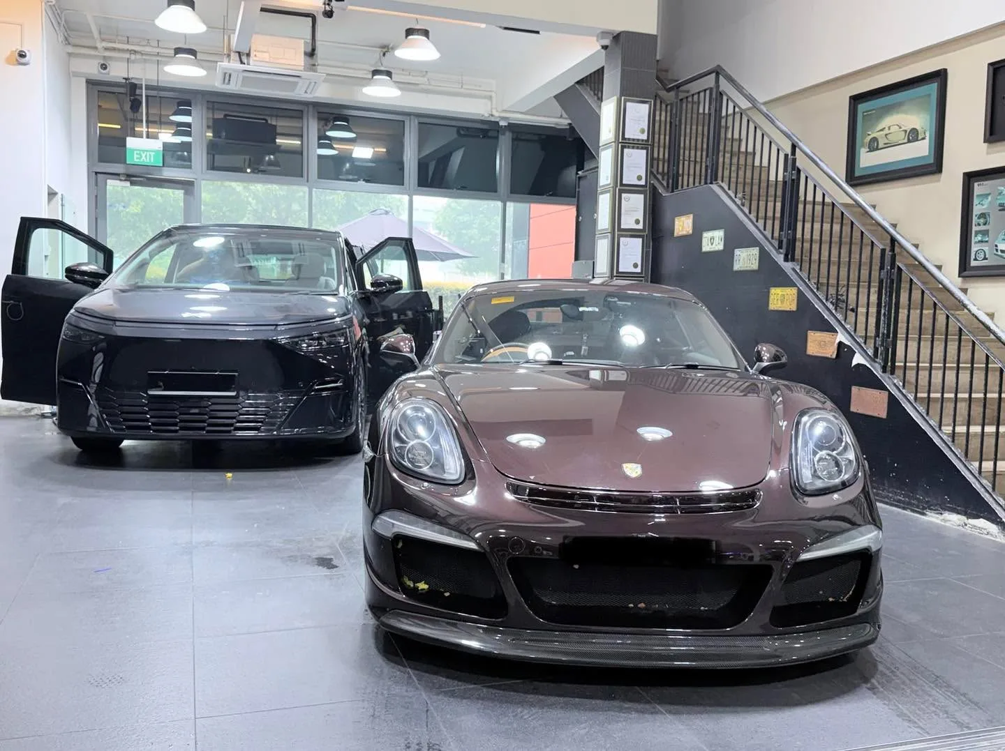 Dark red Porsche sports car with distinctive round headlights in the workshop.