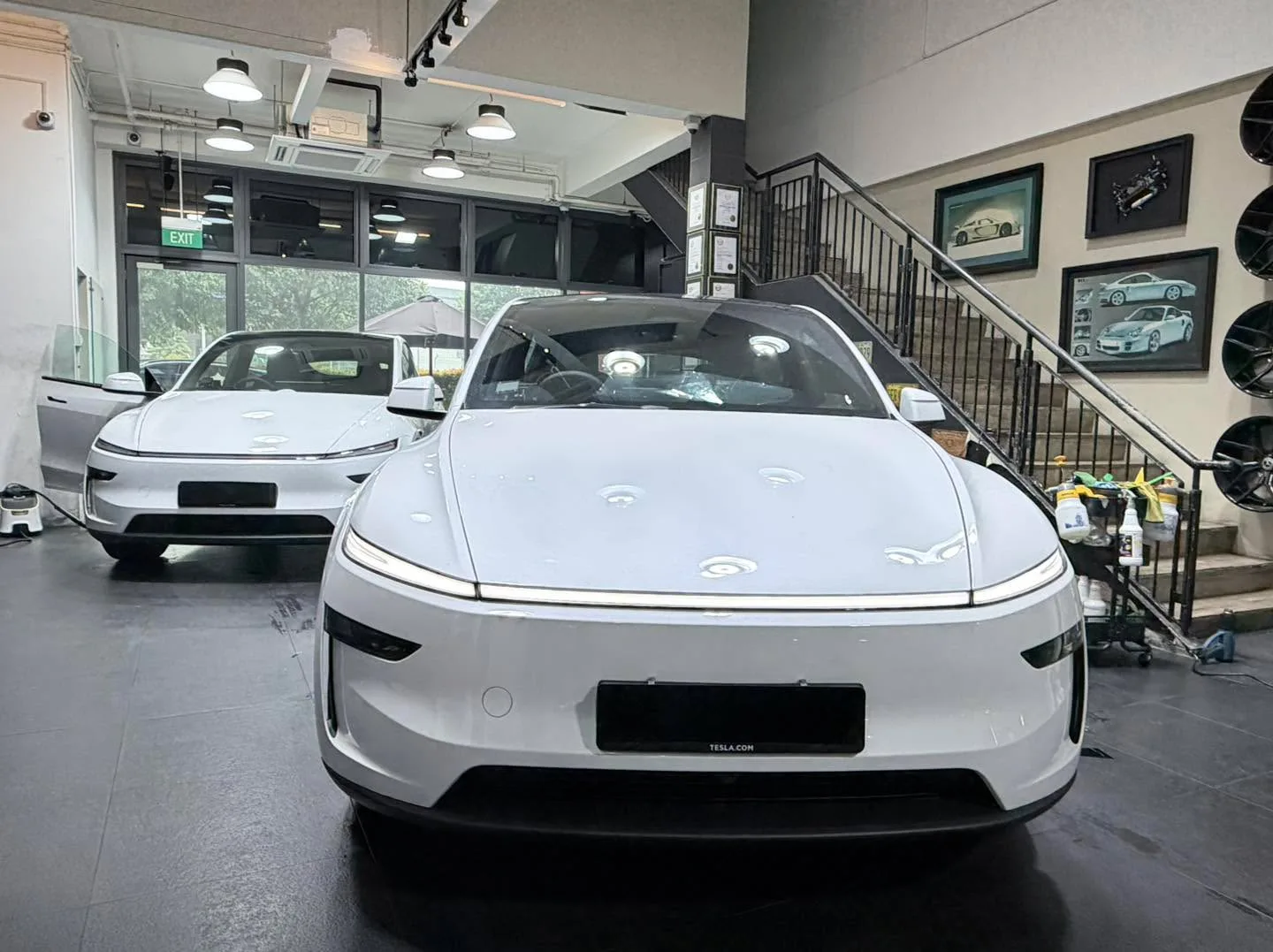 White Tesla electric SUV viewed from the front in the workshop.