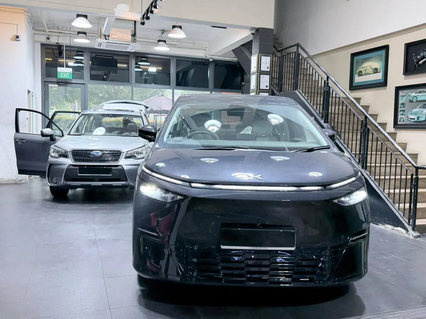 White Subaru SUV and grey Peugeot SUV in the workshop.