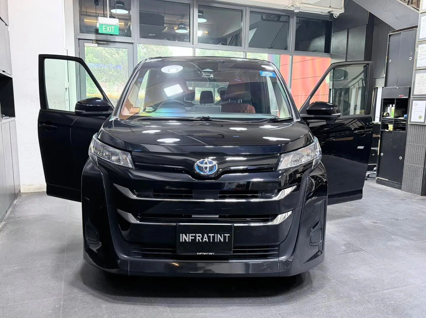 Grey XPENG electric SUV with doors open in the workshop.