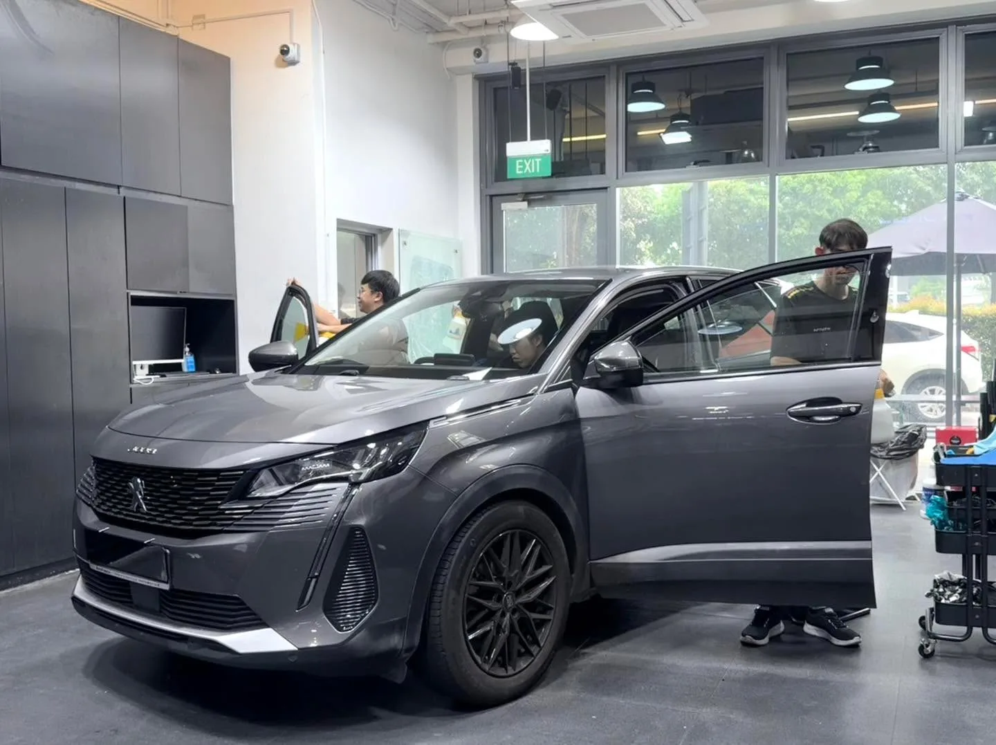 Black Toyota MPV in the workshop with doors open.