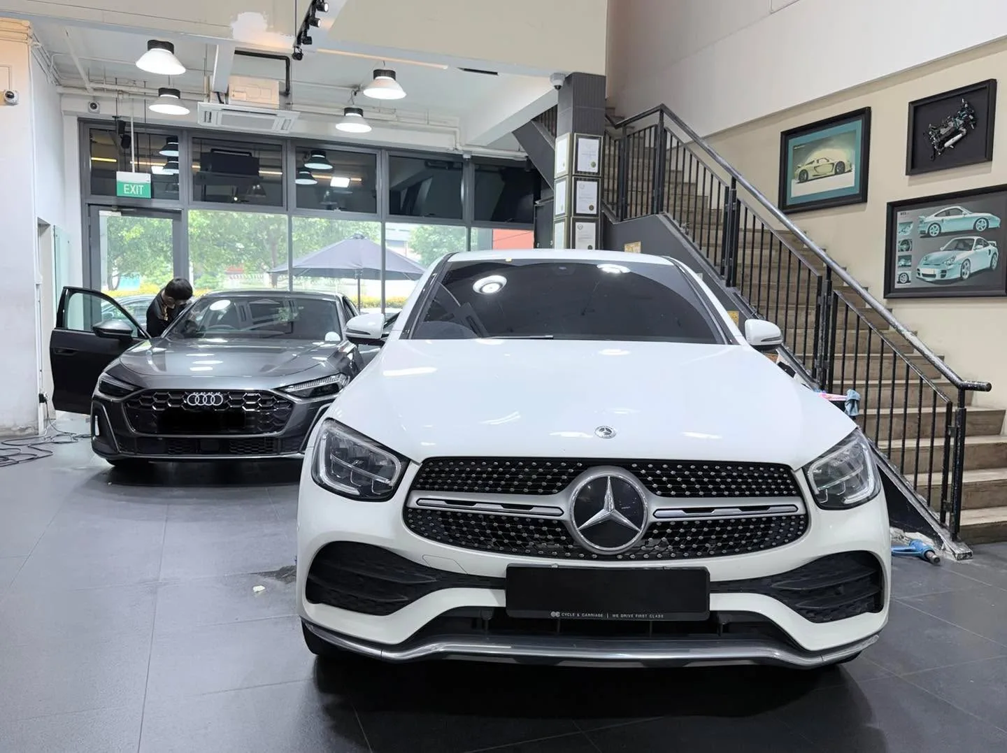 A white Mercedes-Benz GLC in the foreground and a dark Audi A5 visible to the left.