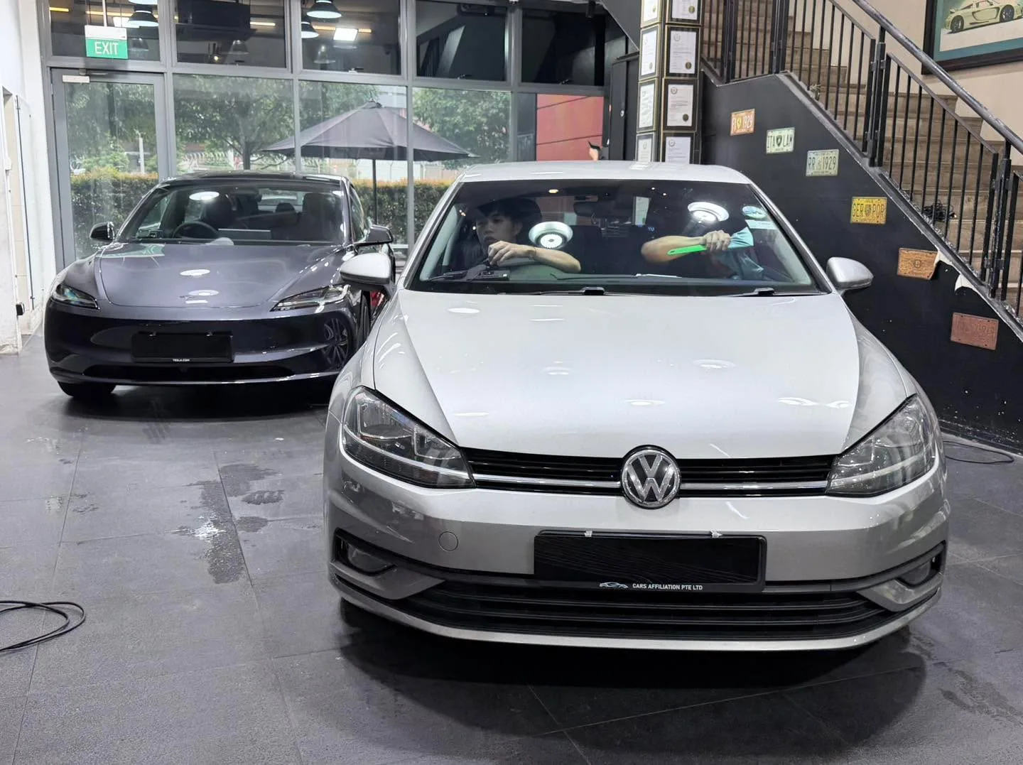 A white Volkswagen Golf compact hatchback, viewed from the front with its door open.