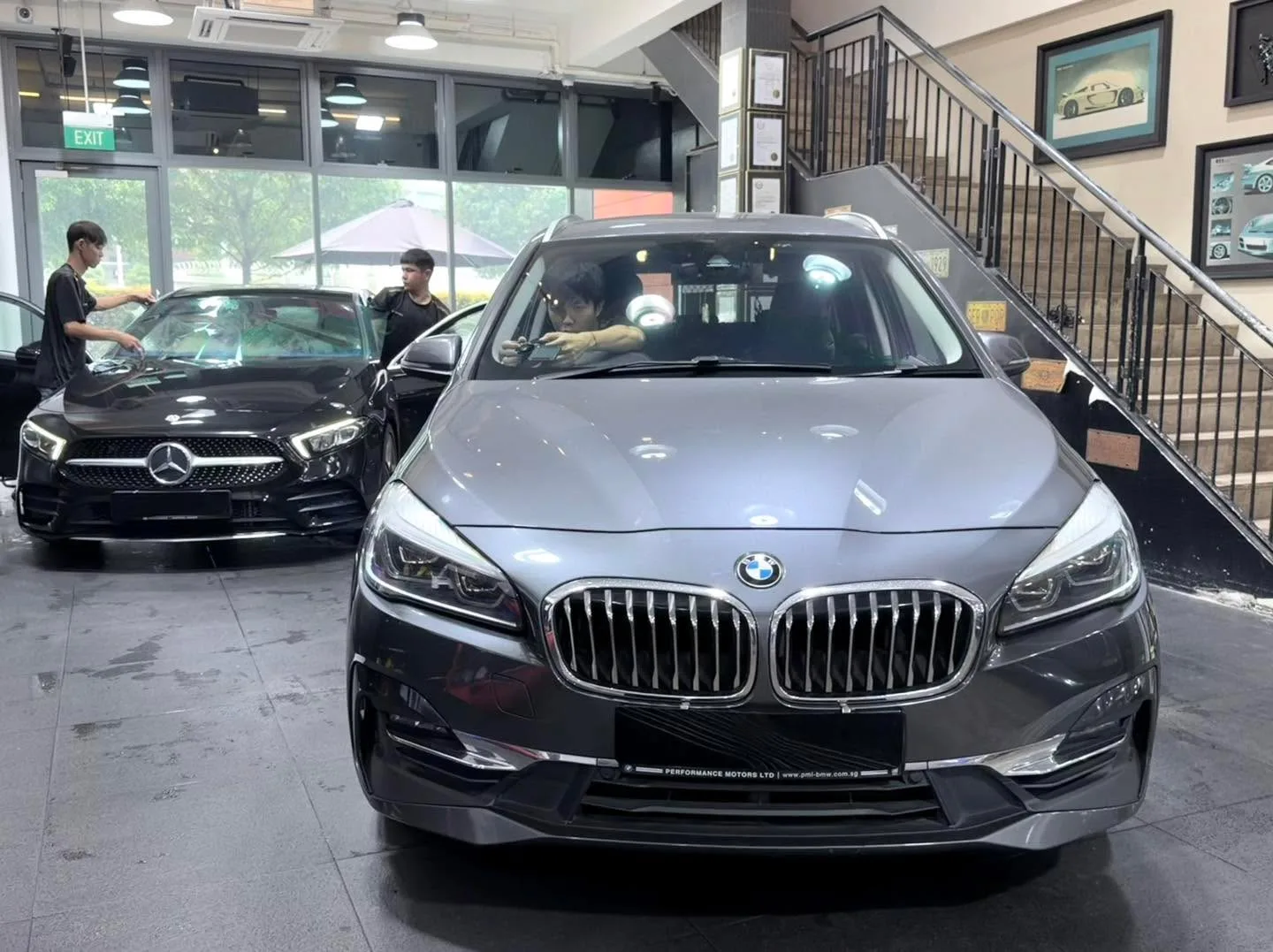 A silver BMW saloon with double-kidney grille viewed straight-on in the workshop interior.