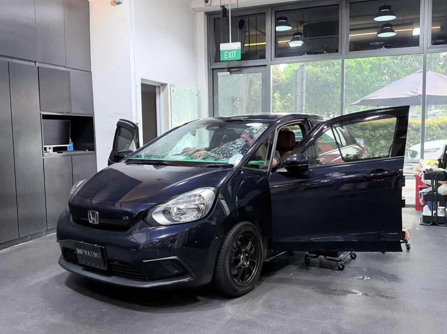 A black BMW X1 SUV with doors closed in the workshop.