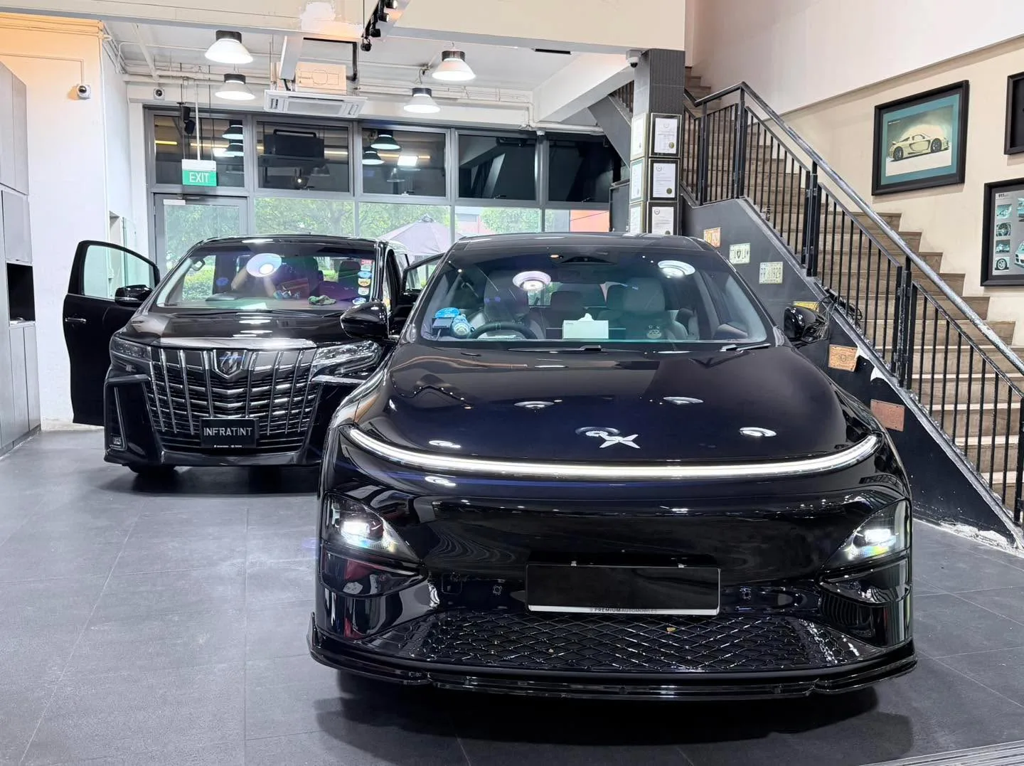 A black Lexus RX and a black Toyota Alphard inside the workshop.