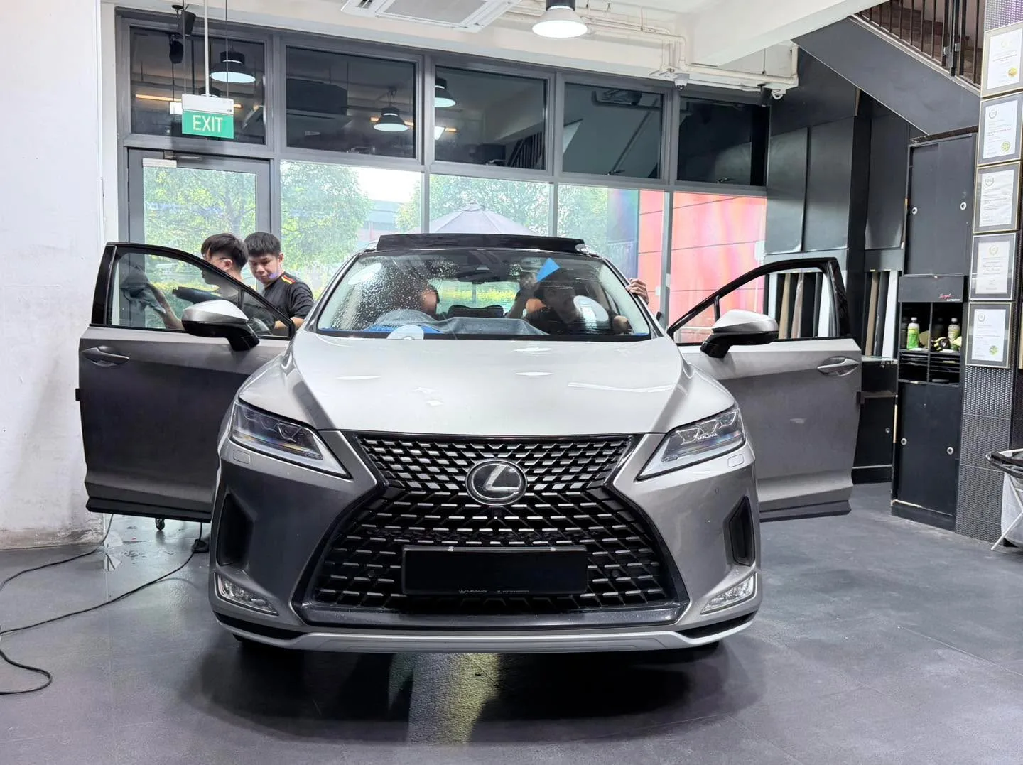 A silver Lexus RX SUV with both doors open, interior visible.