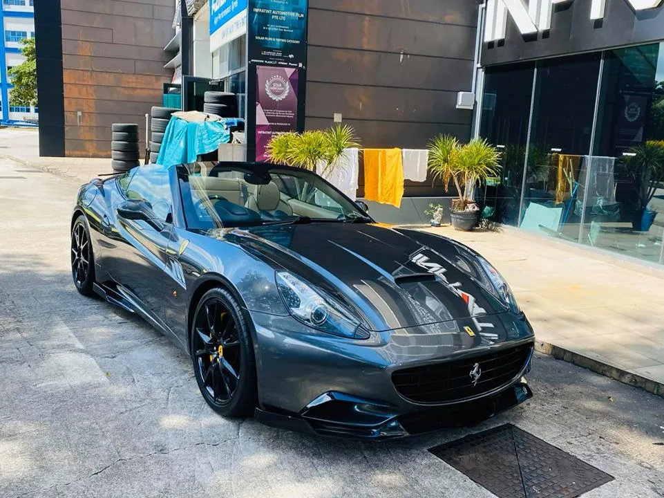 Dark grey Ferrari California convertible outside the Infratint Singapore shopfront