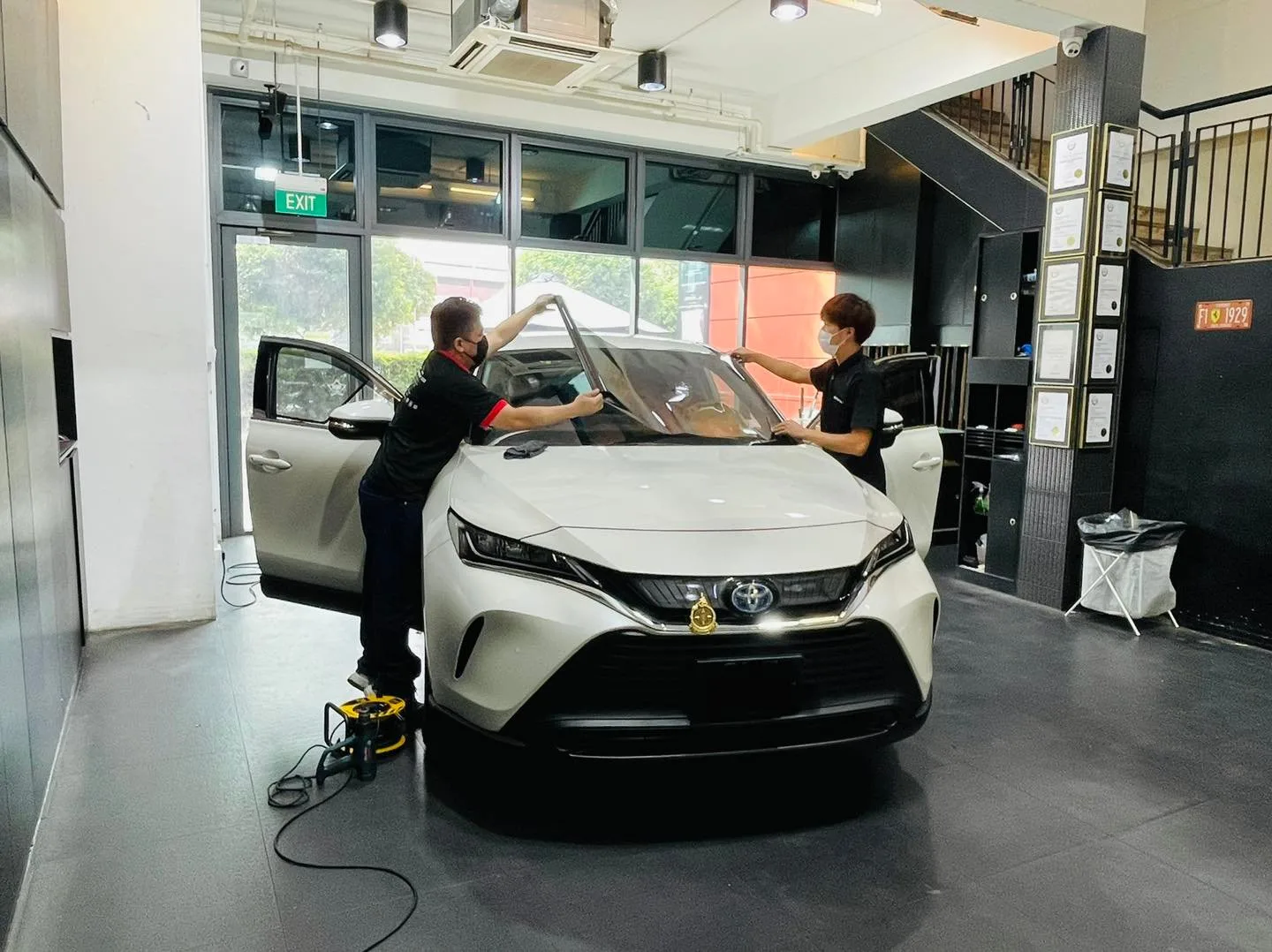 Installers applying window film to a white Toyota Harrier at Infratint Singapore