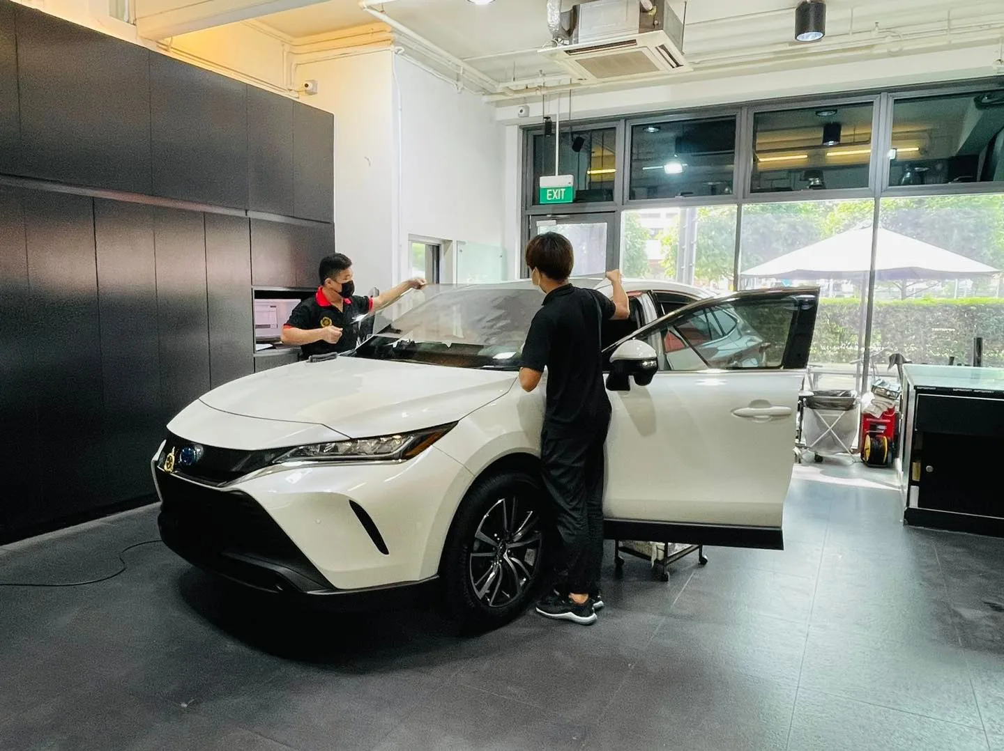 White Toyota Harrier with door open during window film install at Infratint Singapore