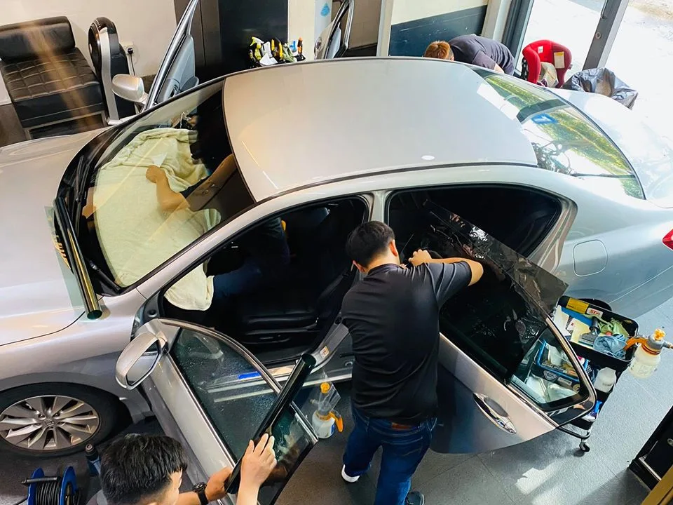Overhead view of technicians tinting the windows of a silver Honda Accord at Infratint Singapore