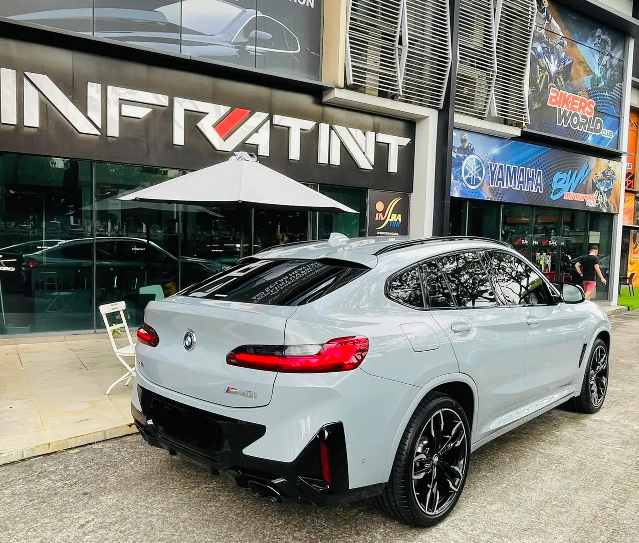 Grey BMW X4 rear three-quarter view outside the Infratint Singapore shopfront after tinting