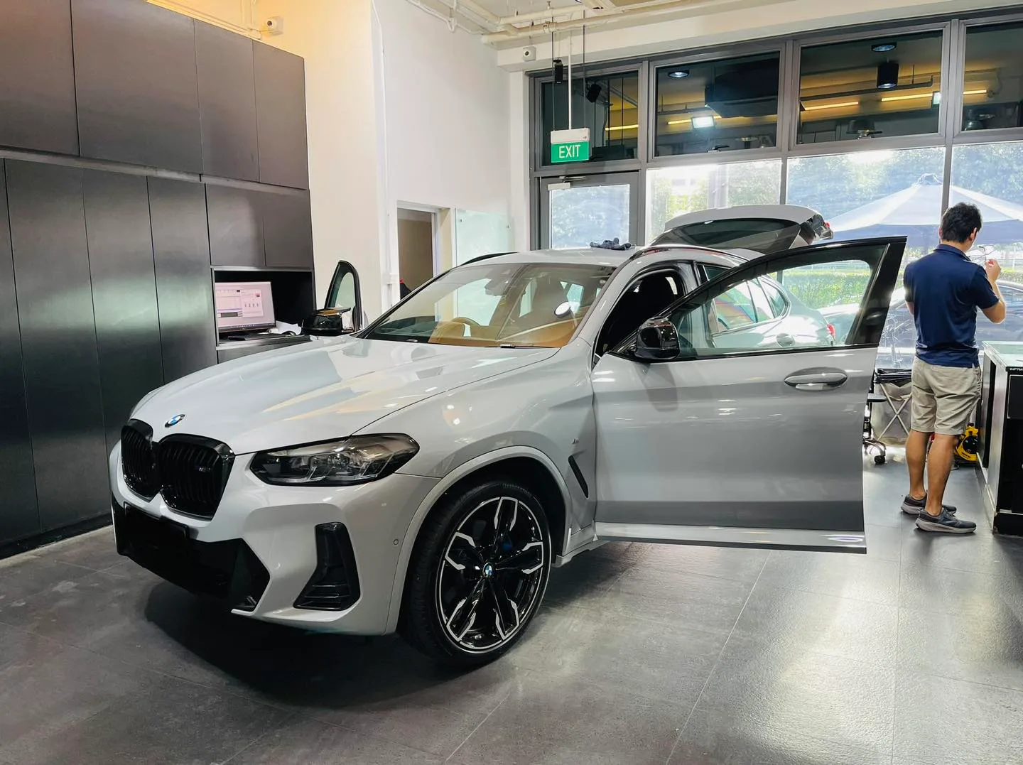 Grey BMW X4 side profile during window film installation at Infratint Singapore