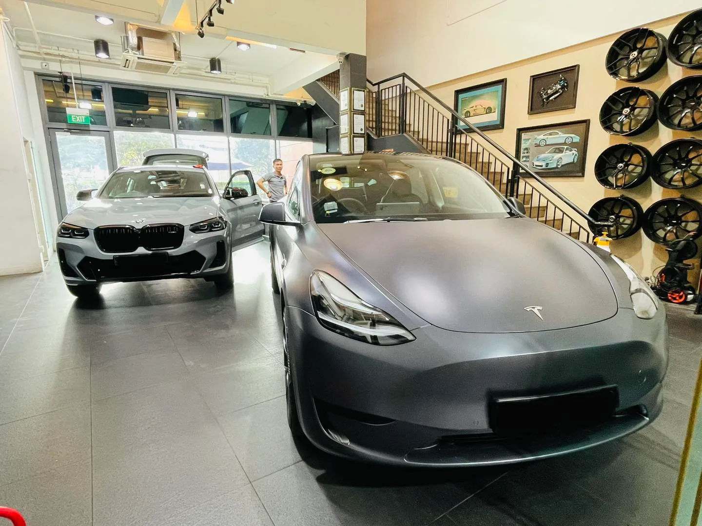 Satin grey Tesla Model Y and a grey BMW SUV inside the Infratint Singapore showroom