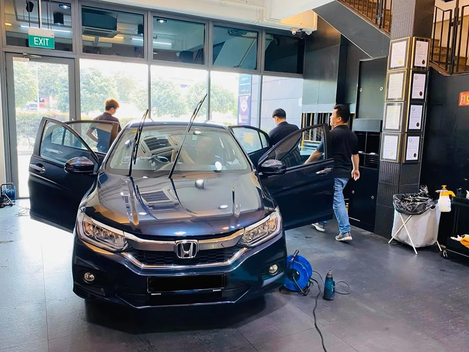 Dark blue Honda sedan with doors open during window tinting at Infratint Singapore
