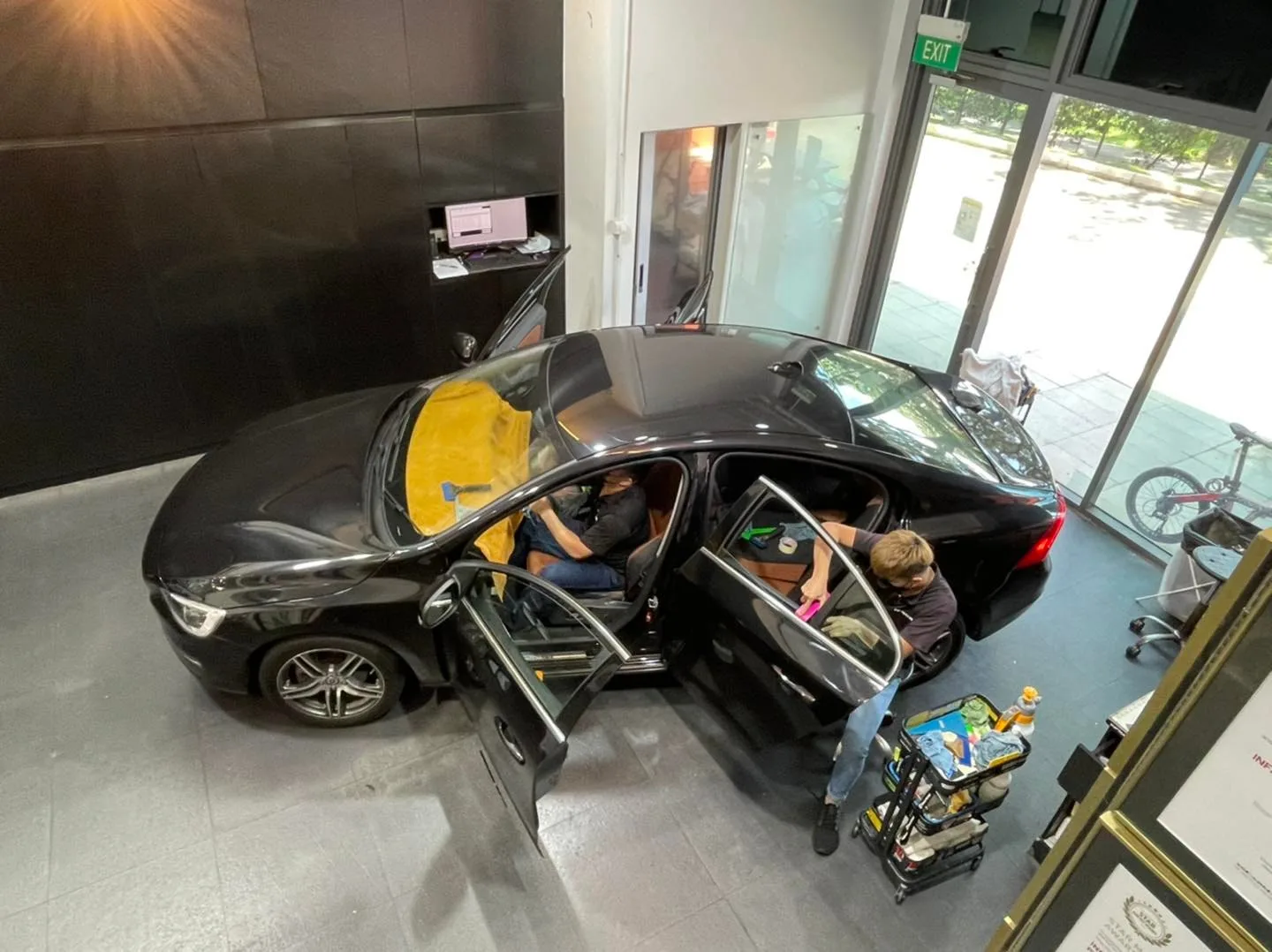 Overhead view of a black sedan being tinted at Infratint Singapore