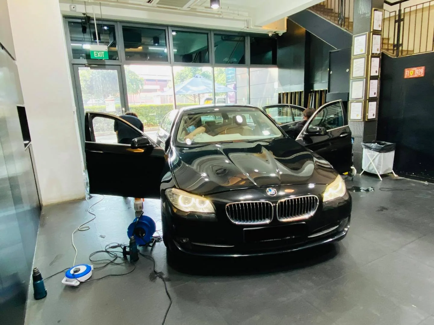 Black BMW 5 Series front view during window film installation at Infratint Singapore