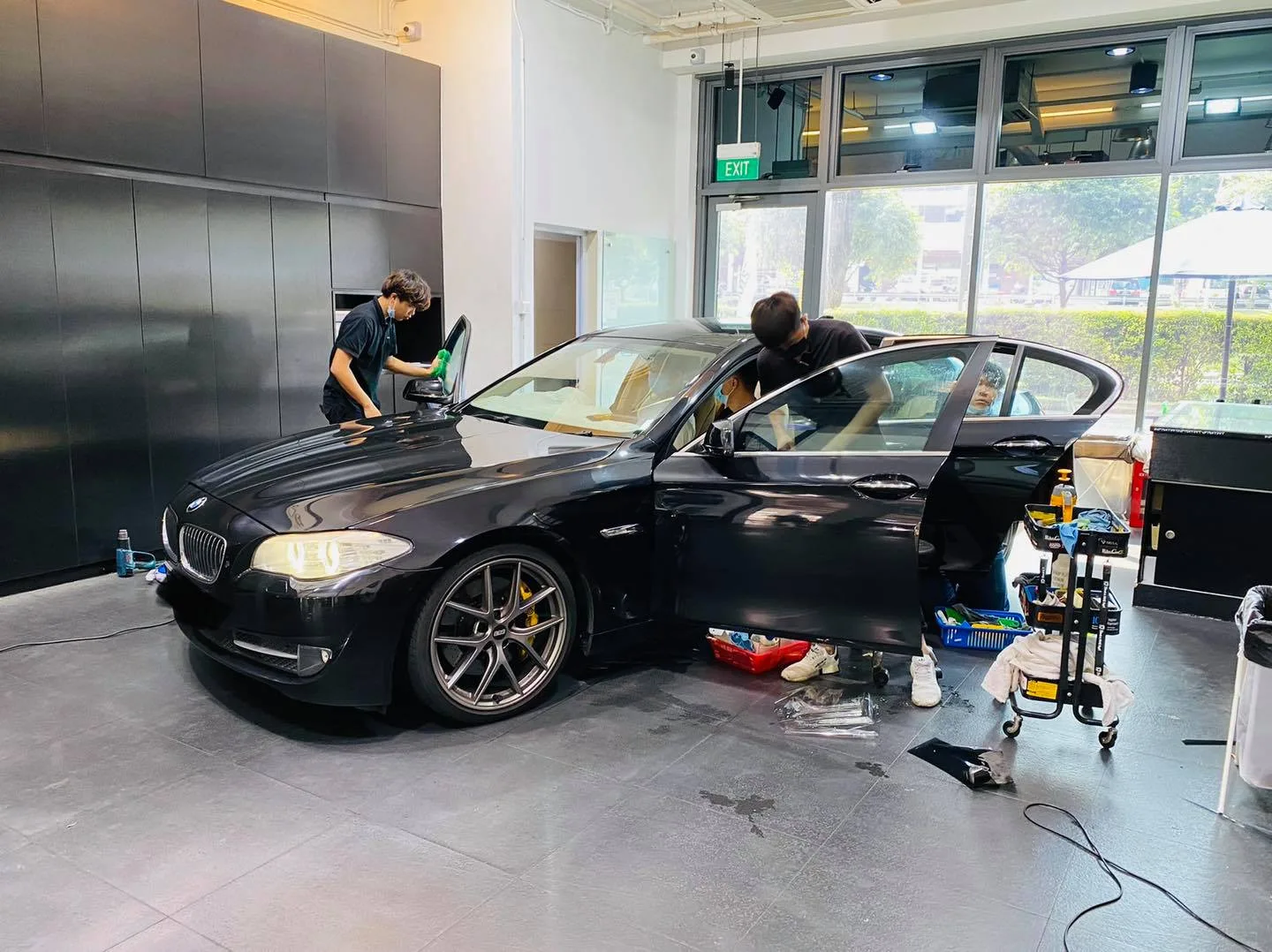 Black BMW 5 Series window tinting with two installers at Infratint Singapore